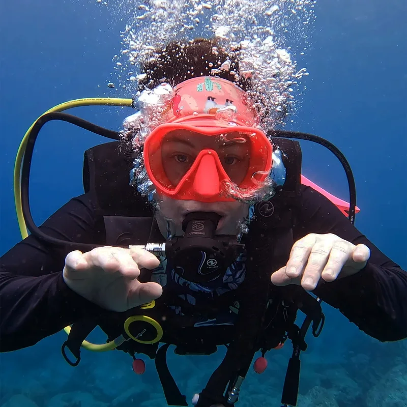Mariya scuba diving in a red mask