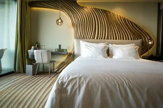 A luxury hotel suite with a made king bed