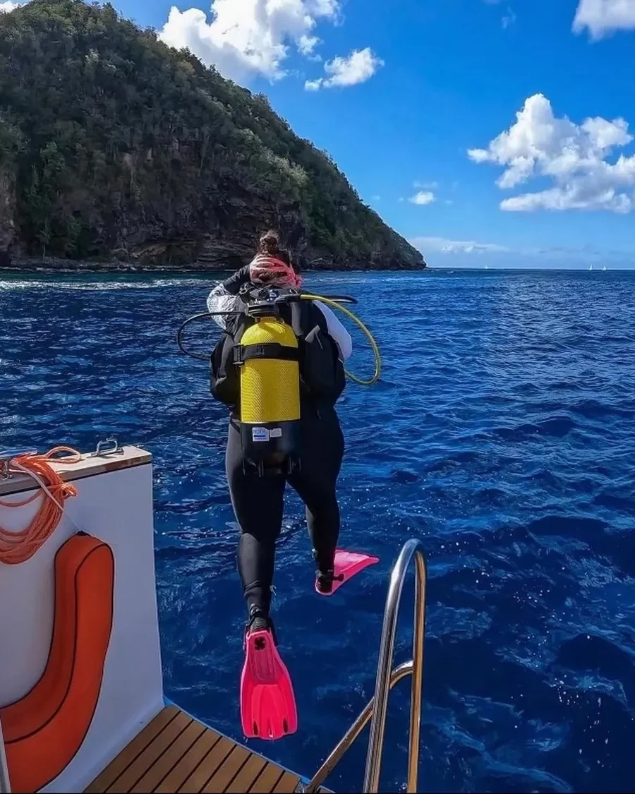 Mariya stepping off the dive boat in pink fins
